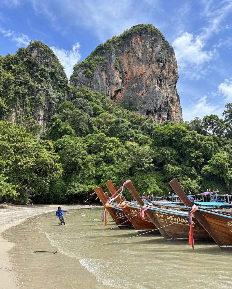 Longtailboten op het strand onder kalksteenrotsen in Thailand
